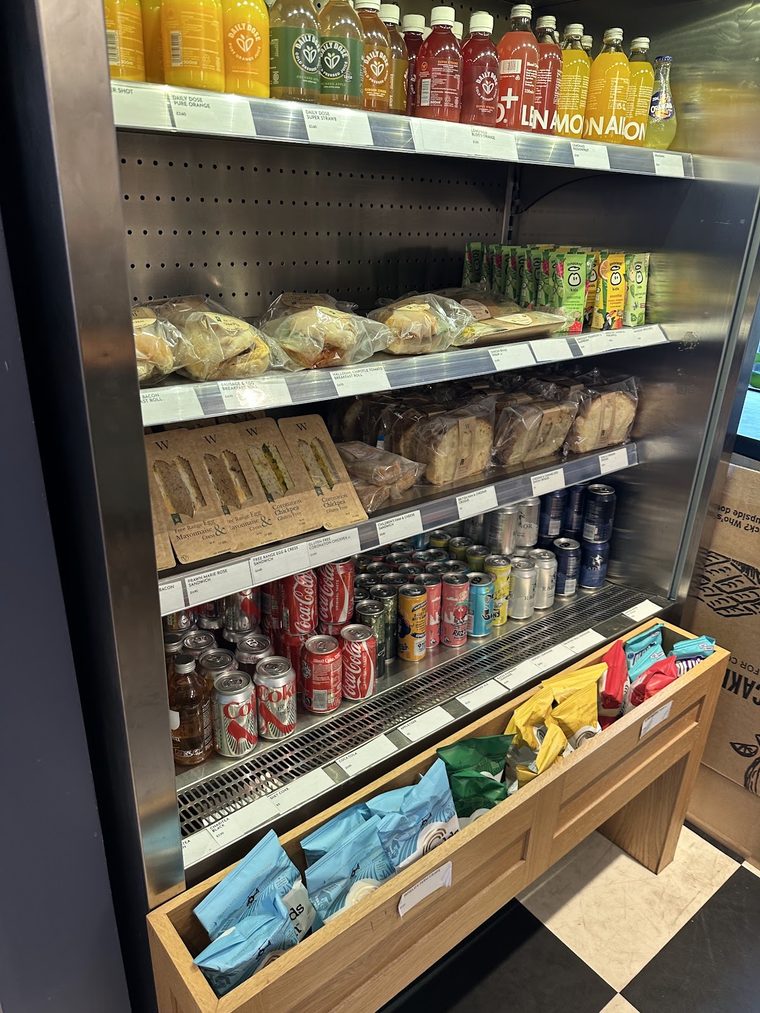 The chilled fridge of bottled soft drinks, cans and wrapped sandwiches